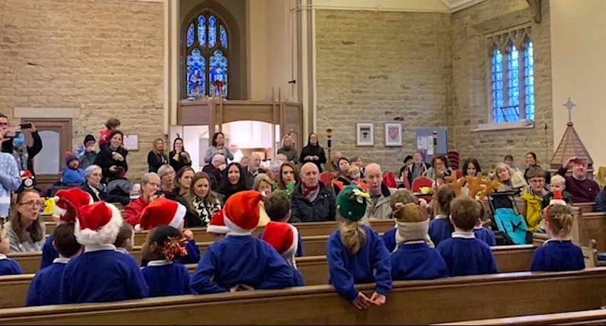 Parents and friends listen to school pupils singing in church.